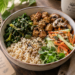 Vegetarian Buddha bowl with brown rice, cooked soy chunks, sautéed mushrooms, leafy greens, carrot and cucumber salad, and mixed seeds.